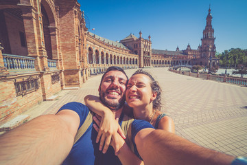 happy smiling couple take photo selfie in Spain square (plaza de espana) in Sevilla, Spain