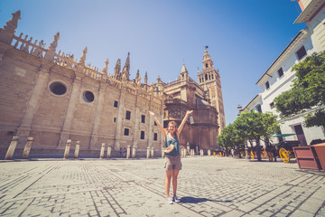 Obraz premium szczęśliwa uśmiechnięta dziewczyna turysta robi selfie na placu Hiszpanii (plaza de espana) w Sewilli w Hiszpanii
