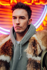 Fashionable man walk outdoors wear  fur jacket with street background - Image