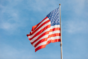 American flag on the blue sky with clouds