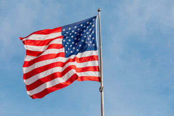 American flag on the blue sky with clouds