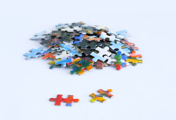 Cardboard multicolored puzzles on a white background. Close-up.