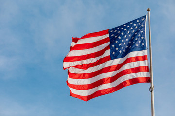 Obraz premium American flag on the blue sky with clouds