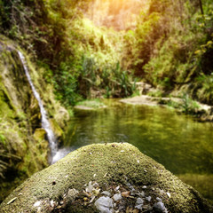 Naklejka na ściany i meble Exotic waterfall background with green moss space for your product. Summer time on Madagascar 