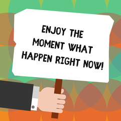 Conceptual hand writing showing Enjoy The Moment What Happen Right Now. Business photo showcasing Seize the day Relax Leisure Hu analysis Holding Colored Placard with Stick Text Space