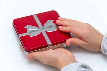 Female hands holding christmas or valentines day gift. Isolated on white background. Top view