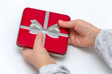 Female hands holding christmas or valentines day gift. Isolated on white background. Top view