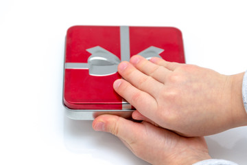 Female hands holding christmas or valentines day gift. Isolated on white background. Top view