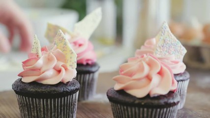 Female hands decorating chocolate muffins