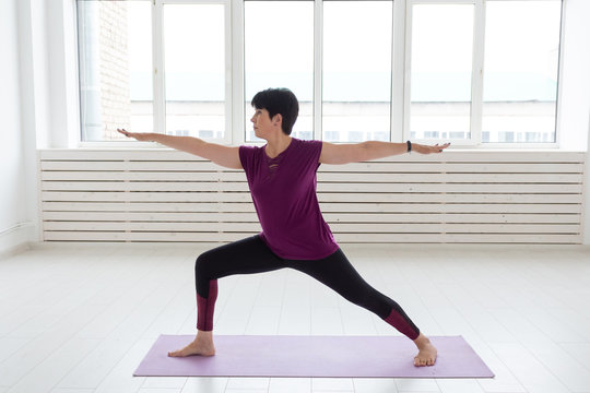 Yoga, people concept - a middle-aged woman doing a yoga and try to do a asana