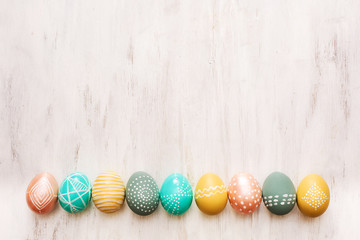 decorated easter eggs on white wooden background