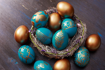 golden decorated easter eggs on dark wooden background