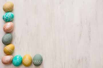 decorated easter eggs on white wooden background