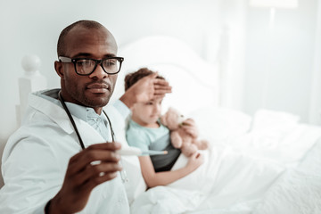 Obraz premium Close up of serious medical worker that checking temperature