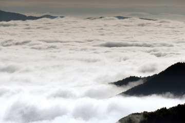 A white mist has covered Rhodope mountain in Bulgaria. Sea of thick fog. Only the high parts of the mountain can be seen.