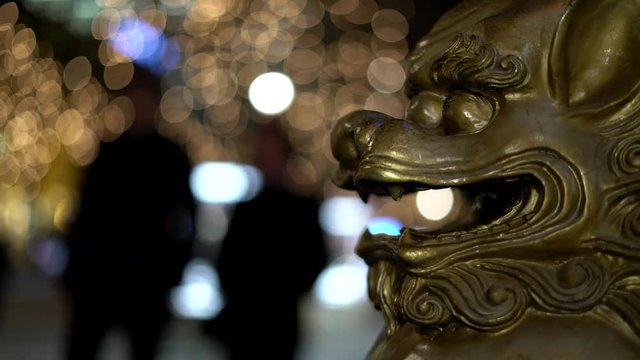 Chinese, Imperial guardian lions. Lion, foo dogs. Traditional Chinese architectural ornament. Stone lions, shishi. On the street of Europa. European Town. People pass behind. Christmas street.