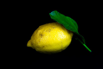 lemon with leaf isolated on a black background