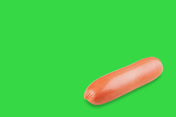 Single prepared long sausage on green background with copy space for your text