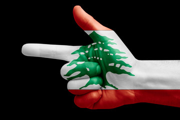 hand symbol with a sign of a gun, painted with the flag of lebanon