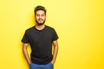 Indian bearded man standing isolated on yellow background