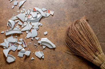 Pieces of shattered dishes. Fragments of the broken white ware on the floor.
