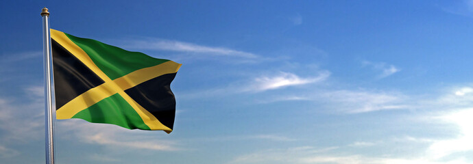 Flag of Jamaica rise waving to the wind with sky in the background