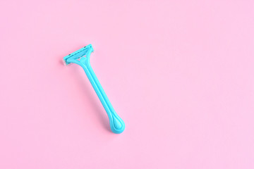 One green woman shave sharp razor with selective focus. New disposable plastic razor with steel blade for daily safety personal shaving on pink neutral background with empty space for text