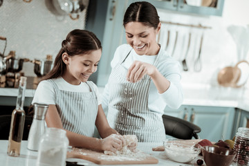 Happy mother and daughter cooking a tasty dinner together