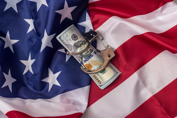 American dollars in handcuffs on national flag