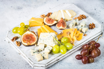 Cheese plate with grapes, figs and nuts. 