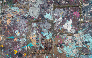 Sol en brique taché par de nombreuses couleurs de peintures