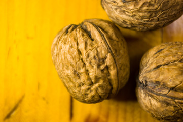 Fototapeta premium Whole walnuts on a wooden table, still life, close up