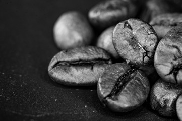 Brown roasted coffee beans on black background, close up, macro