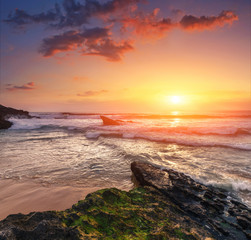 Amazing sunset on the ocean. View of dramatic cloudy sky and stony coast.  Portugal. Concept of the harmony with wildlife, romance, emotional experience in your soul, joy in mundane life.