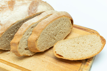 sliced fresh bread on wooden kitchen board, closeup