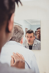 Obraz premium A gay couple together in front of the bathroom mirror.