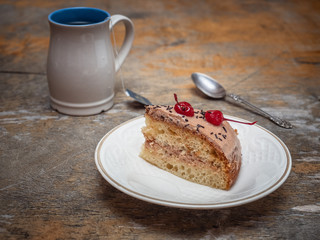 Sweet lunch with cake and tea, a teaspoon lies nearby.