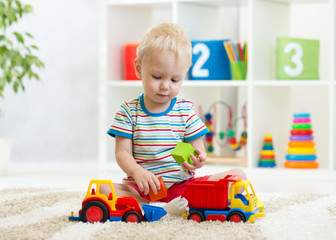 nursery kid boy toddler playing with toys in kindergarten