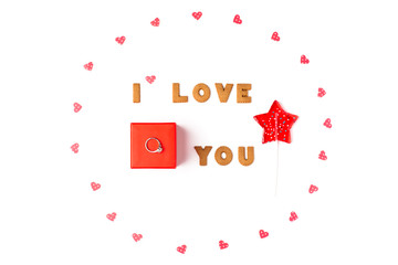 Valentine's day concept. Declaration of love, frame made of paper hearts, lollipop in form star. In the center red gift box with ring. Flat lay, top view, white background, isolated, copy space