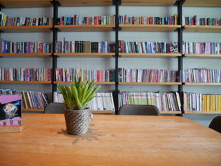 the coffee shop decorate in library style with  blur book shelf 