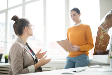 Obraz premium One of girls explaining her opinion or idea to colleague while brainstorming in office at start-up meeting