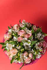 Bouquet of mixed pink and white flowers on red background.