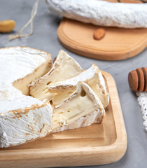 round brie cheese on a wooden cutting board