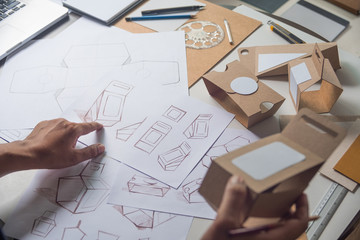 Designer sketching drawing design Brown craft cardboard paper product eco packaging mockup box...