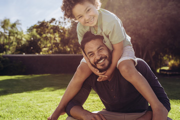 Father and son sitting in park