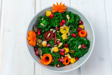 Bowl with calettes (cross between Brussels sprouts and green cabbage), pomegranate seeds, carrots, chickpeas and seeds