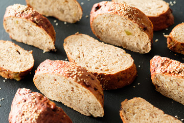 Home made bakery. Pattern composition. Wholegrain bread slices on black background.
