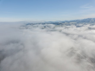 Aerial view of rural landscape in Switzerland covered with fog. Cold morning in winter with beautiful light.