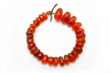 Very beautiful amber beads on a white background. Large orange red amber beads with flat edges. Jewelry women. Sun Stone. Advertising for jewelry shop. Natural mineral. Ancient resin. Sunstone