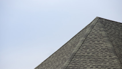 roof shingle background and texture. edge of rubber tile against blue sky. © Rattanachat